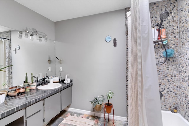 full bathroom with tile patterned floors, baseboards, shower / bath combo with shower curtain, and vanity