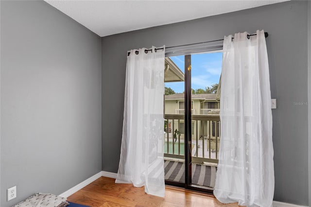 spare room featuring baseboards and wood finished floors