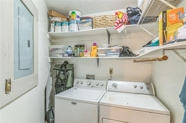 clothes washing area with electric panel, separate washer and dryer, laundry area, and a textured ceiling