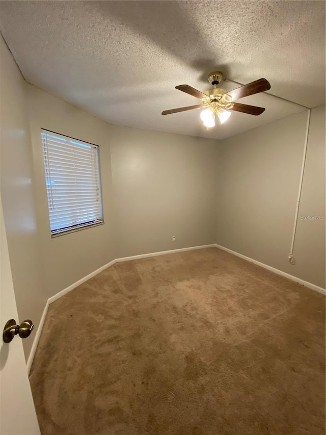 spare room featuring a ceiling fan, baseboards, carpet floors, and a textured ceiling