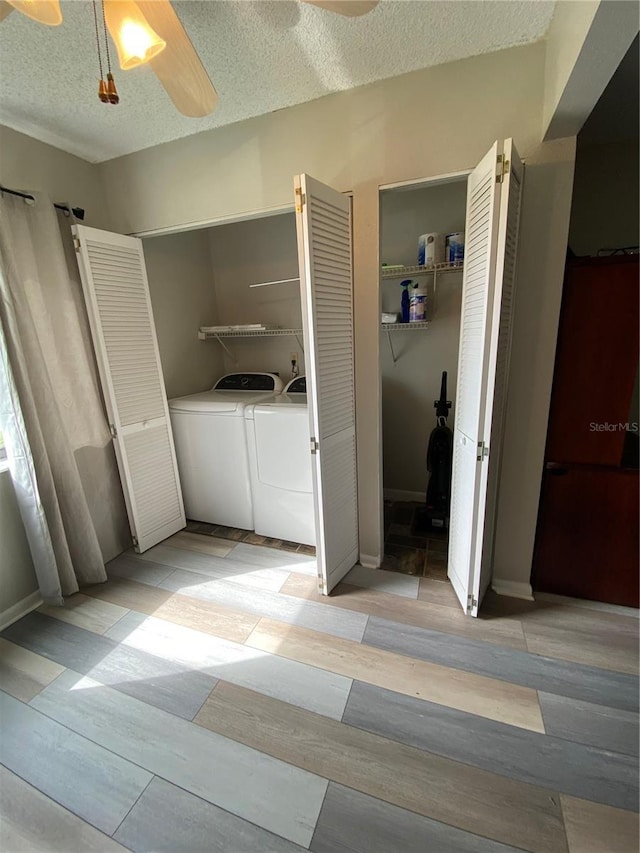 clothes washing area featuring wood finished floors, laundry area, ceiling fan, a textured ceiling, and washer and dryer