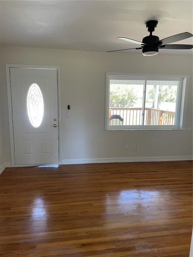 foyer entrance with baseboards, a ceiling fan, and wood finished floors