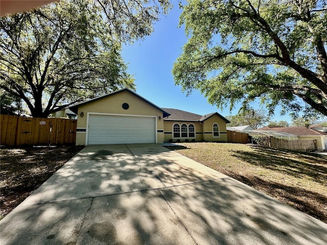 single story home with an attached garage, fence, and stucco siding