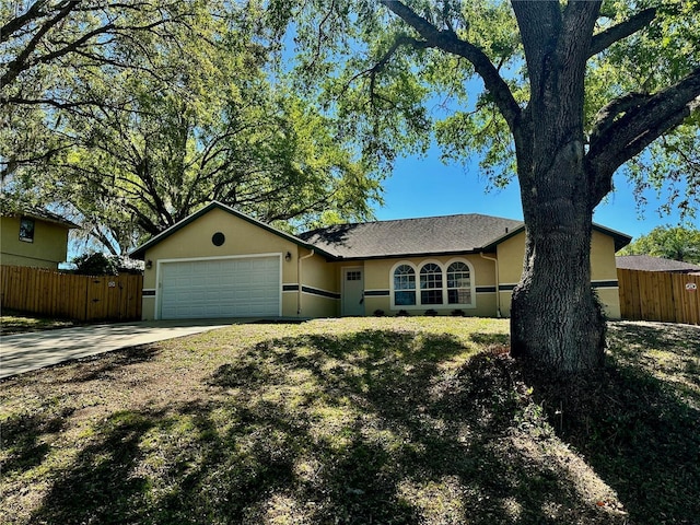 single story home featuring stucco siding, driveway, a garage, and fence