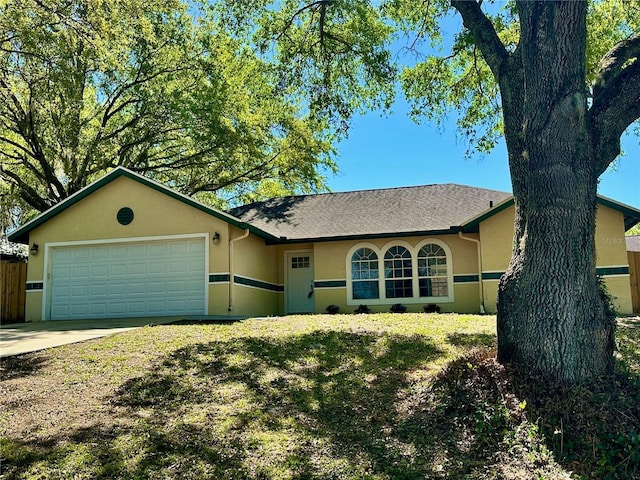 ranch-style house featuring a garage, driveway, and stucco siding