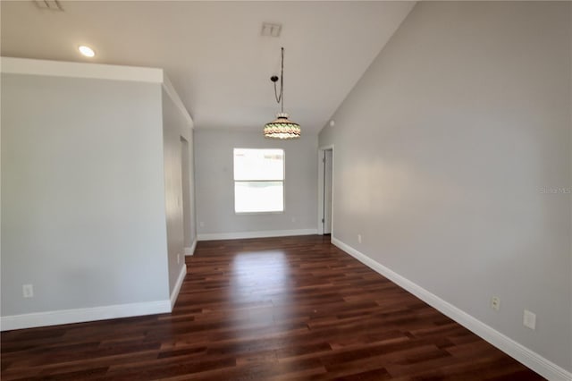 spare room with dark wood-style floors, baseboards, and vaulted ceiling