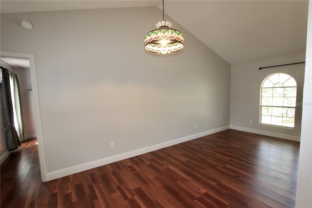 spare room with dark wood finished floors, lofted ceiling, and baseboards