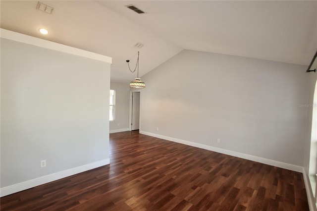 unfurnished room featuring dark wood finished floors, lofted ceiling, and visible vents