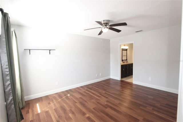 empty room featuring ceiling fan, visible vents, baseboards, and wood finished floors