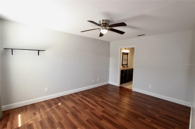 spare room with ceiling fan, wood finished floors, visible vents, and baseboards