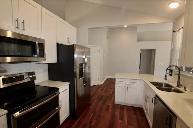 kitchen featuring a sink, tasteful backsplash, stainless steel appliances, white cabinets, and lofted ceiling