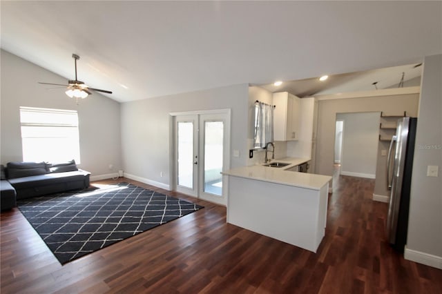 kitchen with a sink, a wealth of natural light, vaulted ceiling, and freestanding refrigerator