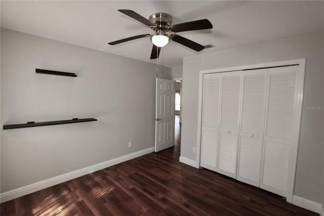 unfurnished bedroom featuring visible vents, baseboards, a closet, dark wood-style floors, and a ceiling fan