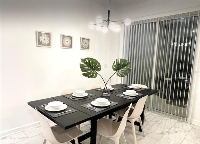 dining room with ornamental molding, baseboards, marble finish floor, and a chandelier