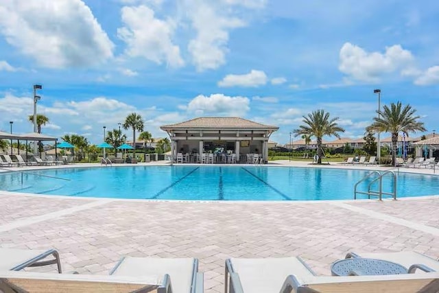 community pool featuring fence and a patio area