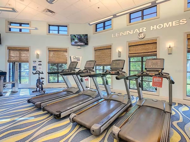 gym featuring visible vents, carpet, and a high ceiling