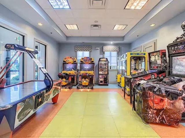 rec room featuring a drop ceiling, visible vents, and a tray ceiling