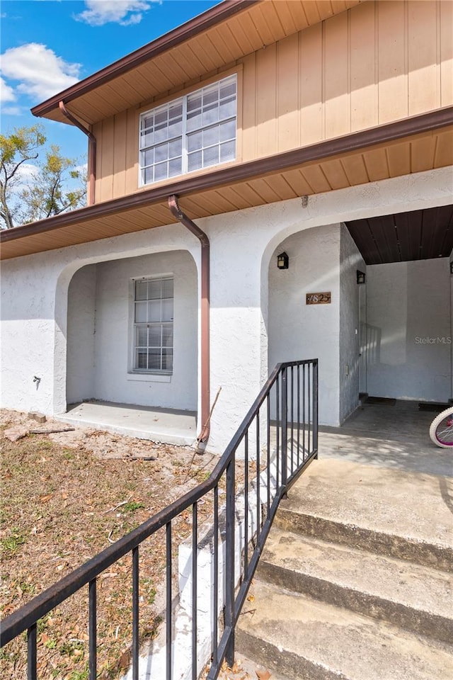 property entrance featuring stucco siding and board and batten siding