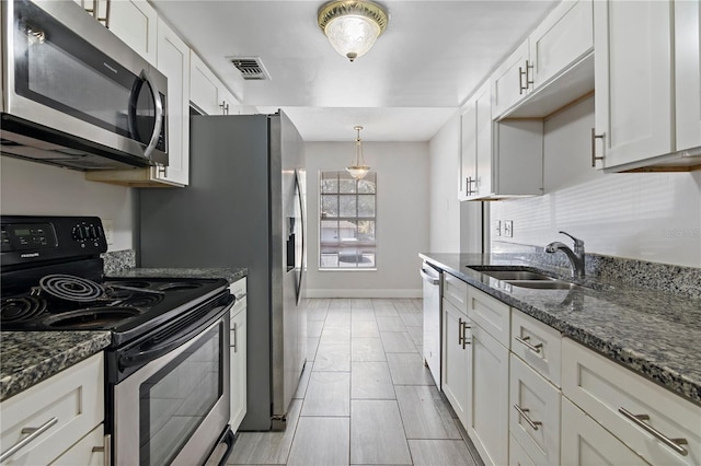 kitchen featuring visible vents, appliances with stainless steel finishes, white cabinetry, and a sink