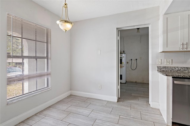 unfurnished dining area featuring wood finish floors, baseboards, and electric water heater