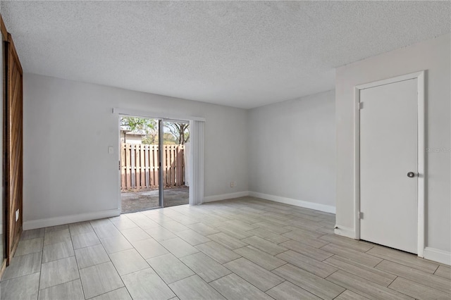 empty room with baseboards and a textured ceiling