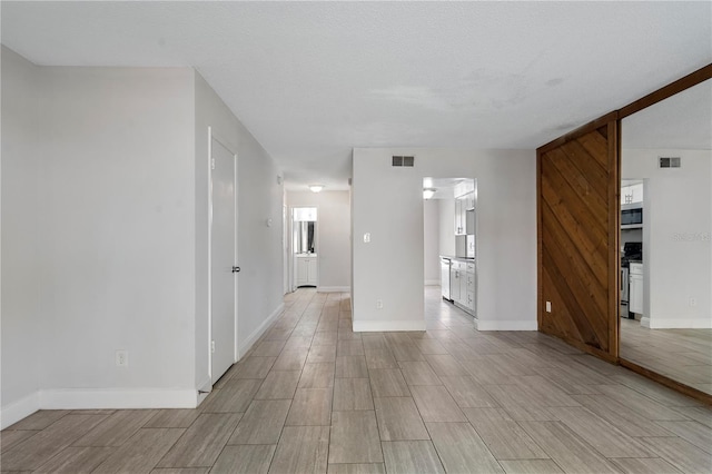 empty room with visible vents, baseboards, and wood finish floors