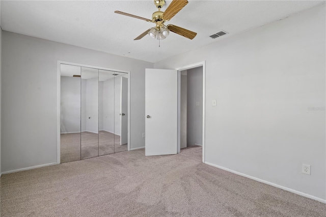 unfurnished bedroom with baseboards, visible vents, carpet floors, and a closet