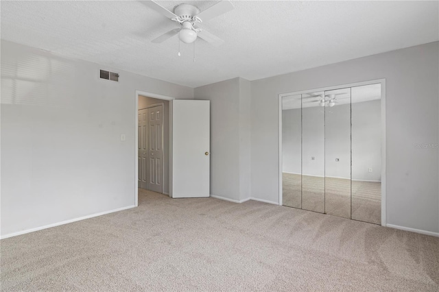 unfurnished bedroom featuring visible vents, carpet flooring, a textured ceiling, and baseboards