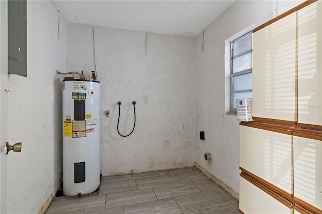 interior space with wood finish floors, laundry area, electric panel, water heater, and washer hookup