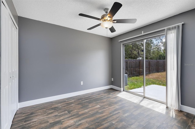 unfurnished room featuring ceiling fan, a textured ceiling, dark wood-type flooring, and baseboards