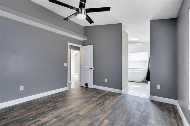 unfurnished room with vaulted ceiling, ceiling fan, baseboards, and wood finished floors