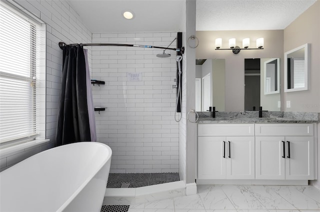 full bathroom featuring a soaking tub, double vanity, a stall shower, a textured ceiling, and marble finish floor