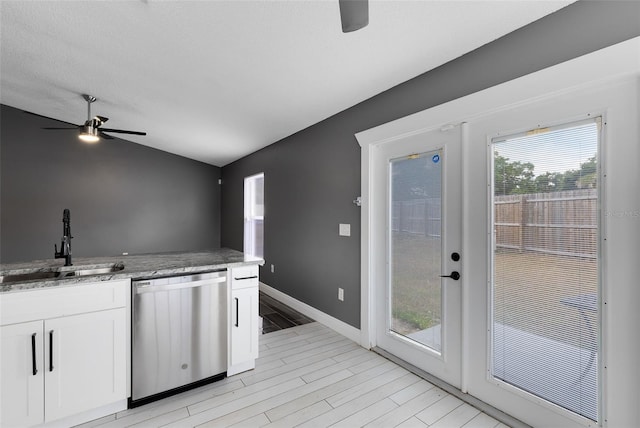 kitchen featuring ceiling fan, light stone countertops, stainless steel dishwasher, white cabinetry, and a sink