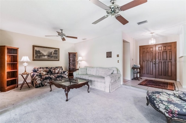 carpeted living area featuring visible vents and ceiling fan with notable chandelier