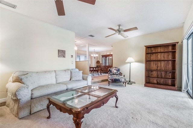 carpeted living area with visible vents, a healthy amount of sunlight, and ceiling fan with notable chandelier