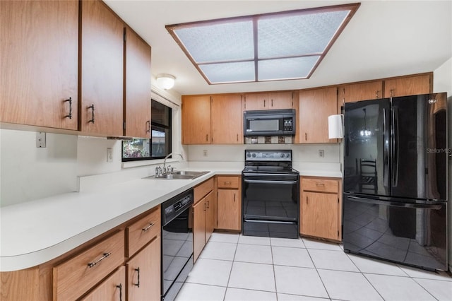 kitchen featuring black appliances, light tile patterned floors, light countertops, and a sink