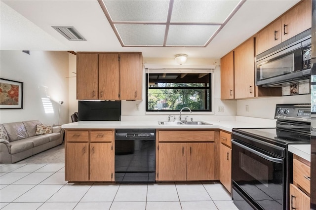 kitchen with visible vents, light countertops, light tile patterned floors, black appliances, and a sink