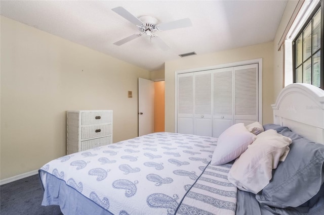 carpeted bedroom with a closet, visible vents, ceiling fan, and baseboards