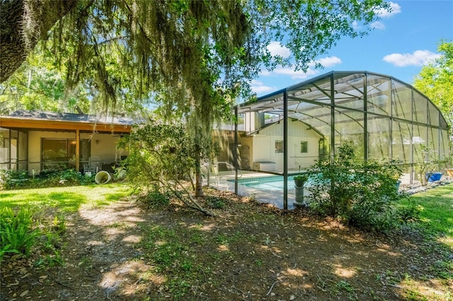 view of yard featuring glass enclosure and an outdoor pool