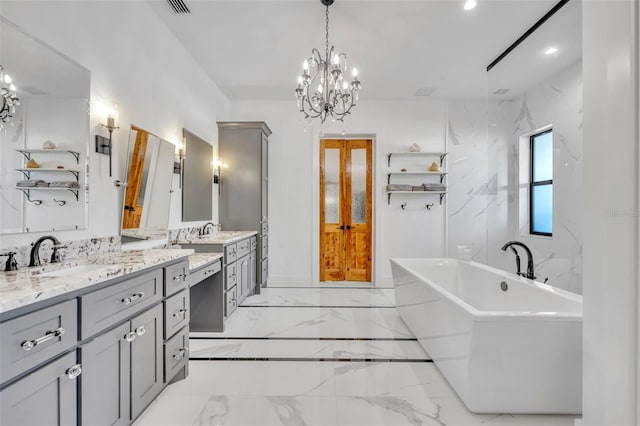 full bathroom featuring a notable chandelier, marble finish floor, a sink, double vanity, and a freestanding bath