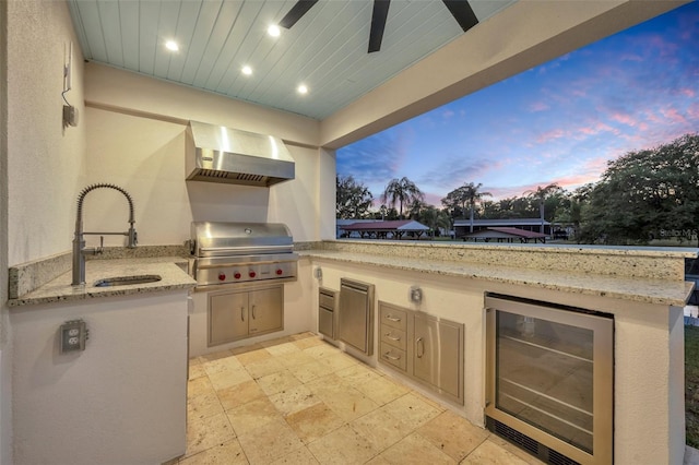 patio terrace at dusk with a sink, area for grilling, wine cooler, and a grill