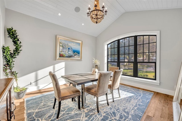 dining area with hardwood / wood-style floors, baseboards, recessed lighting, vaulted ceiling, and a chandelier