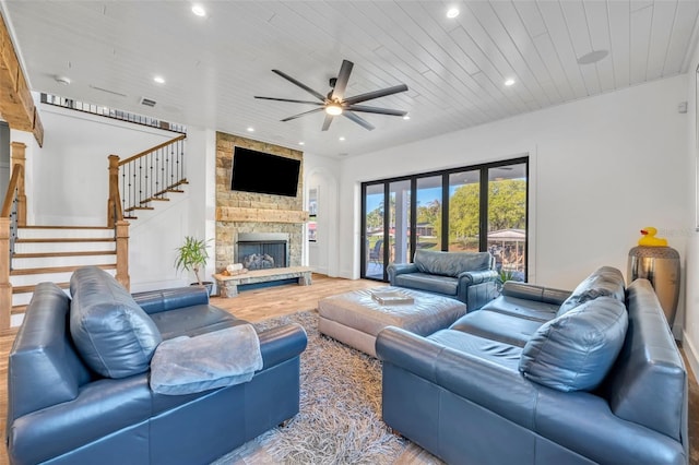 living room with a ceiling fan, wood finished floors, recessed lighting, a fireplace, and stairs