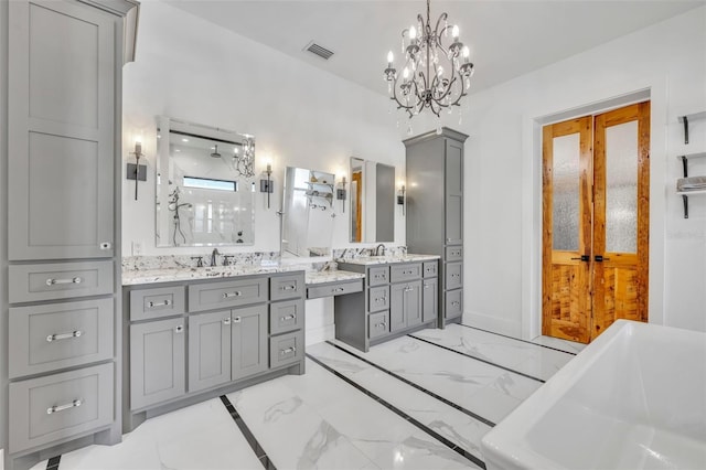 bathroom with vanity, visible vents, a freestanding tub, a notable chandelier, and marble finish floor