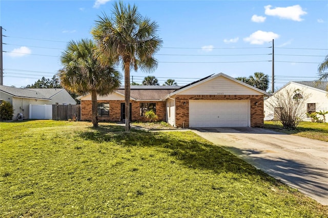 ranch-style house with a front lawn, fence, concrete driveway, an attached garage, and brick siding