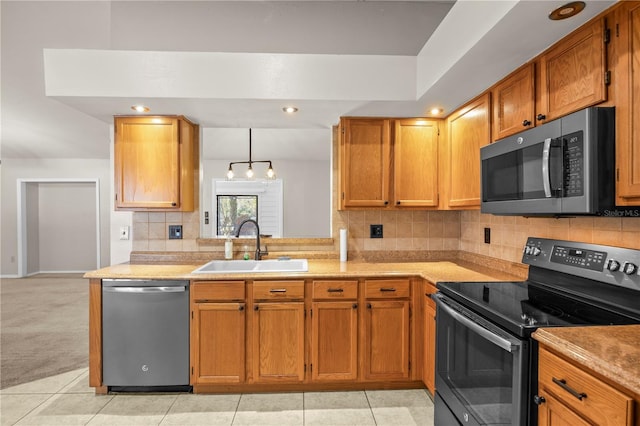 kitchen featuring a sink, light countertops, decorative backsplash, and stainless steel appliances