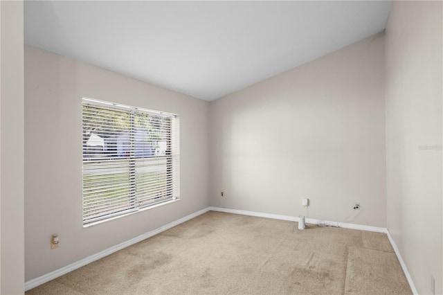 spare room with light colored carpet and baseboards