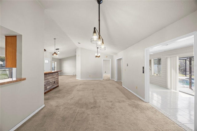 interior space featuring light carpet, light tile patterned floors, baseboards, and vaulted ceiling