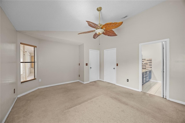 unfurnished bedroom with visible vents, light carpet, a ceiling fan, connected bathroom, and baseboards