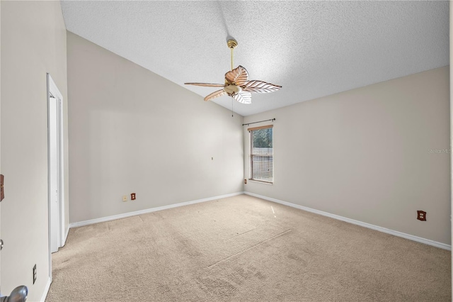 spare room featuring baseboards, ceiling fan, lofted ceiling, carpet floors, and a textured ceiling